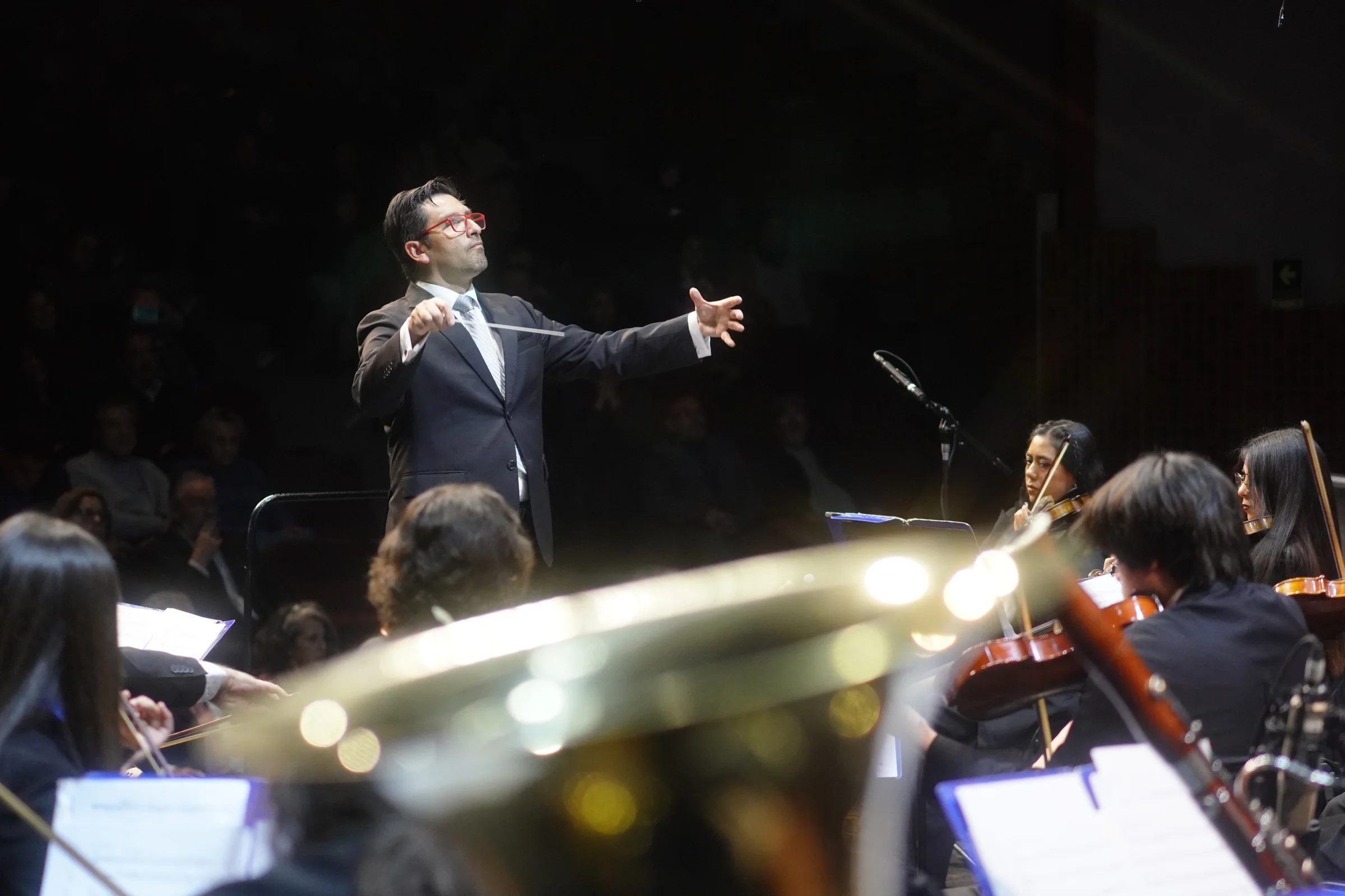 Director musical dirigiendo orquesta sinfónica en concierto