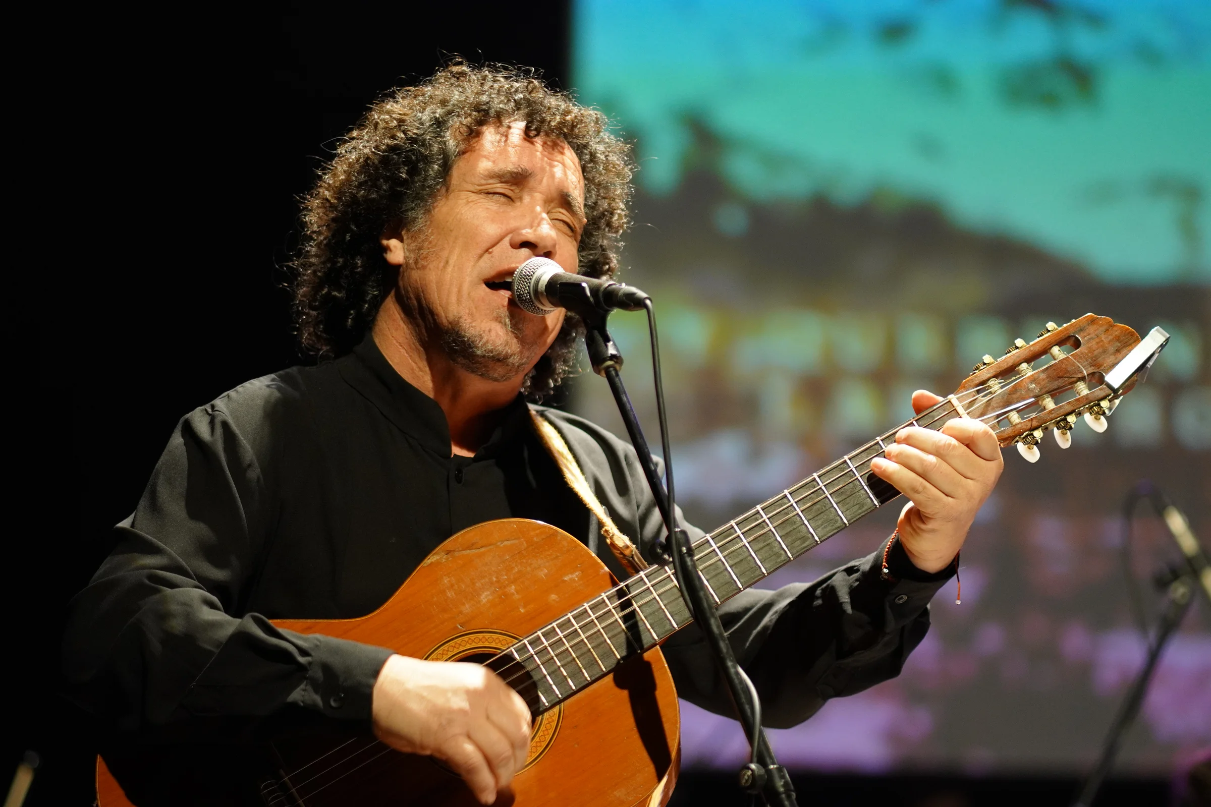 Cantante y guitarrista interpretando en vivo frente al micrófono