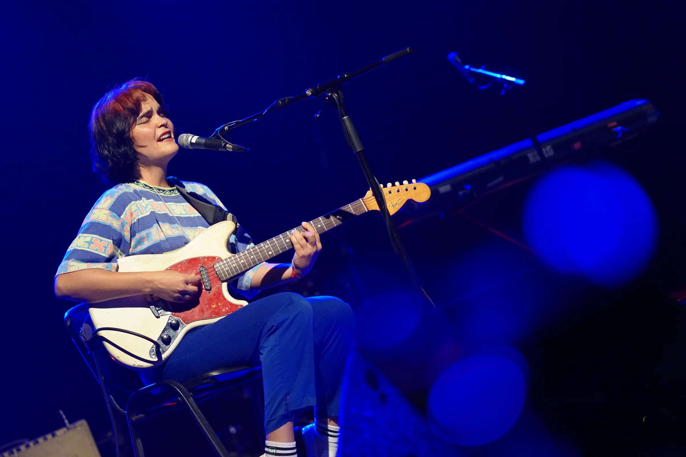 Guitarrista tocando guitarra eléctrica y cantando en presentación musical