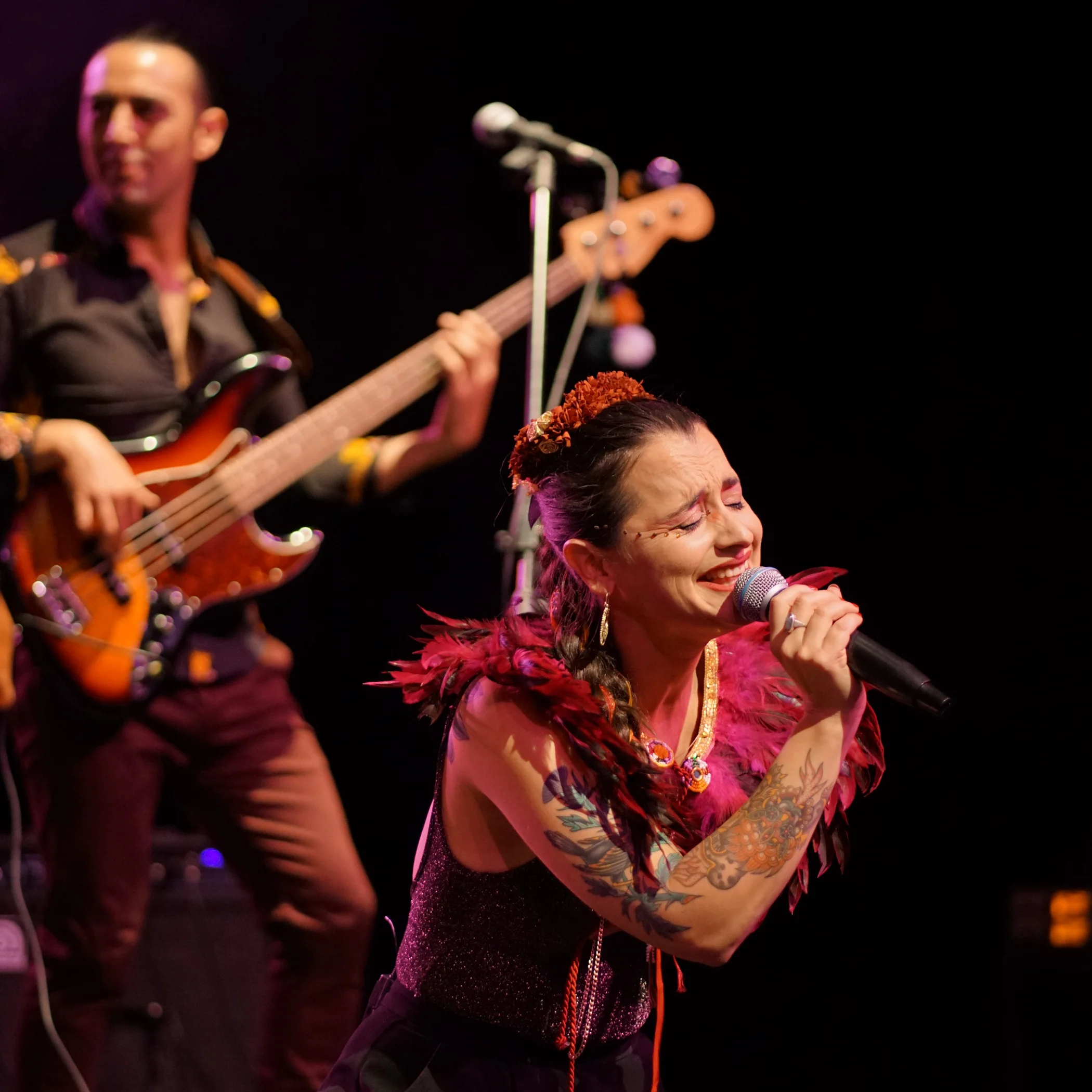 Cantante y bajista actuando en vivo en concierto sobre escenario