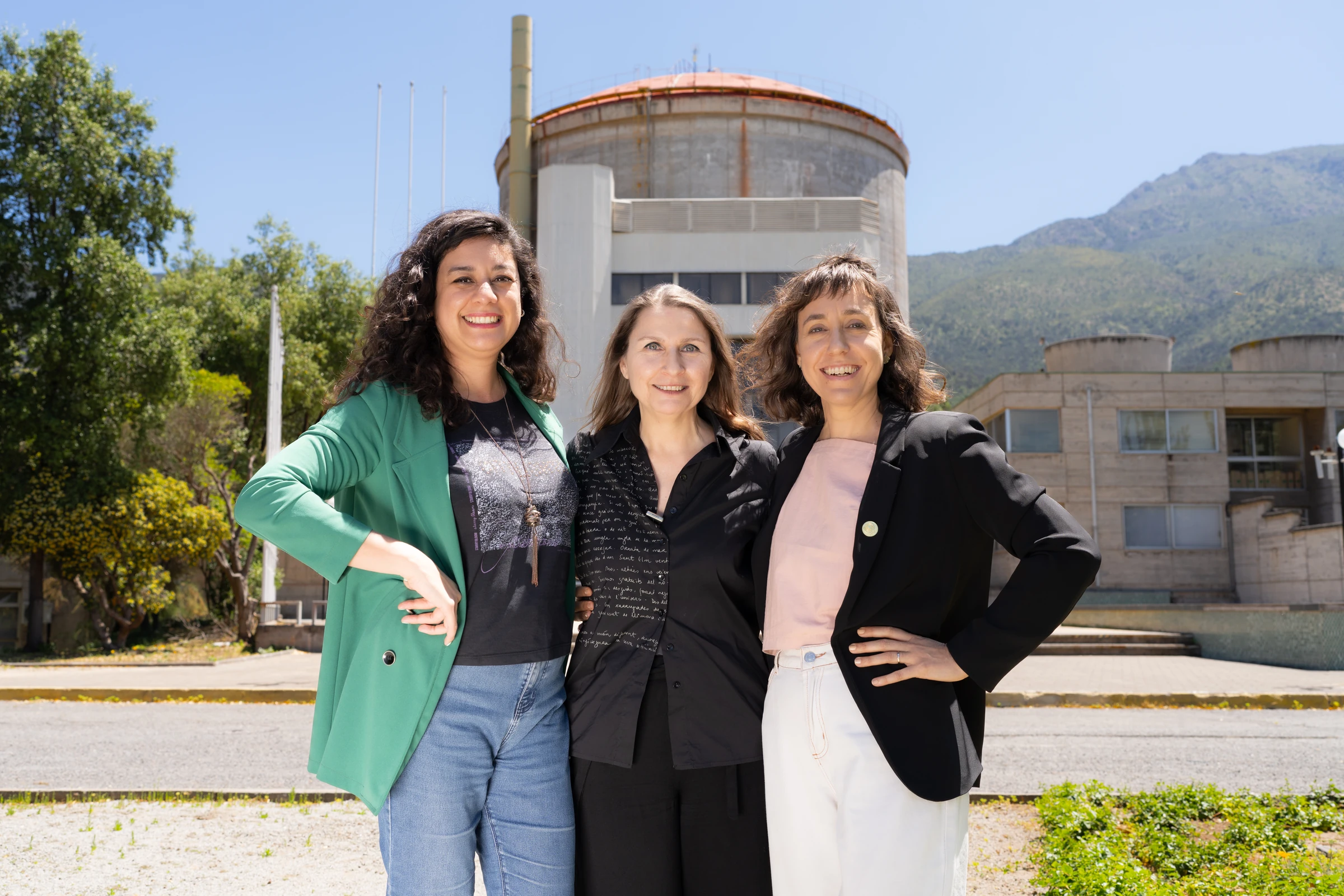 Tres profesionales al aire libre frente a instalaciones institucionales
