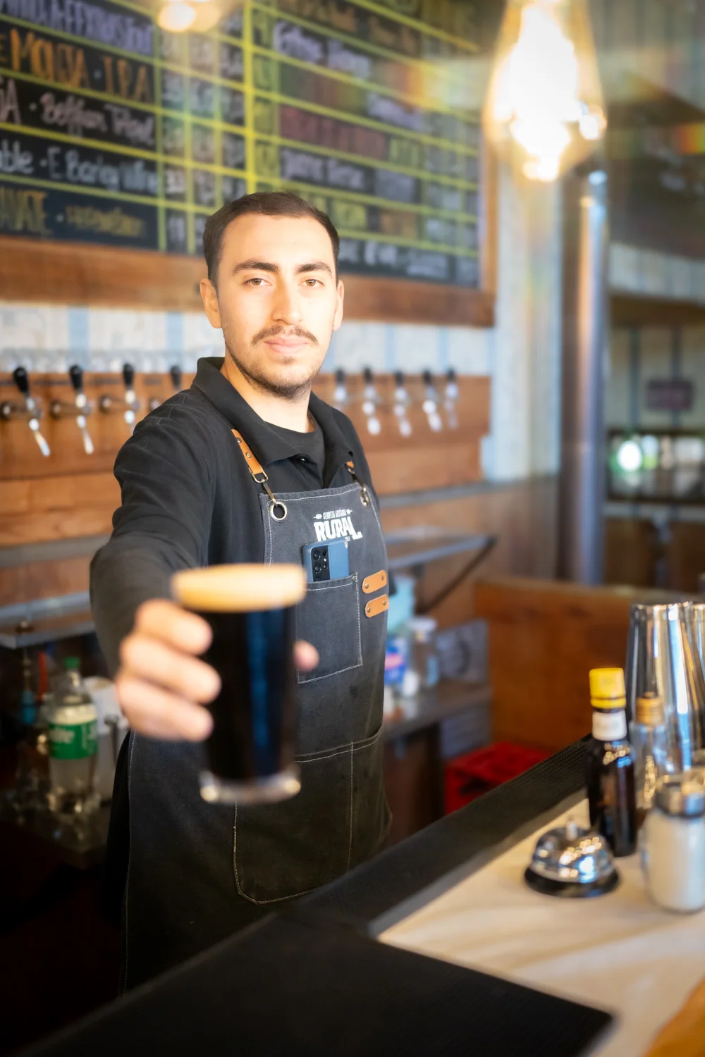Bartender sirviendo un vaso de cerveza artesanal en la barra