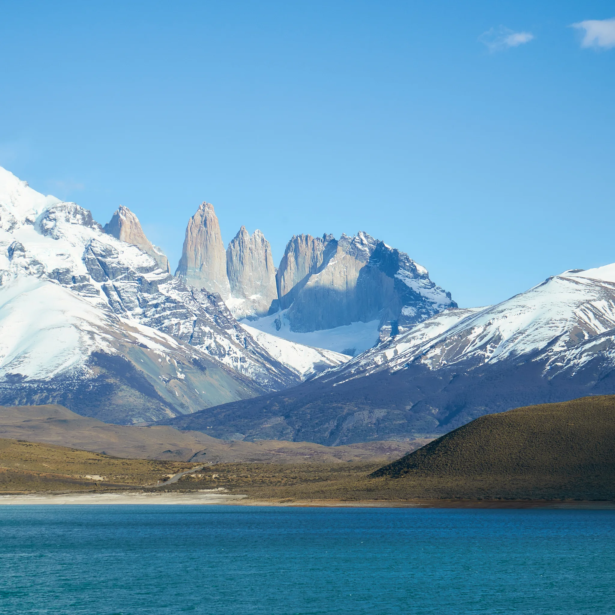 Macizo montañoso nevado sobre lago turquesa en Torres del Paine