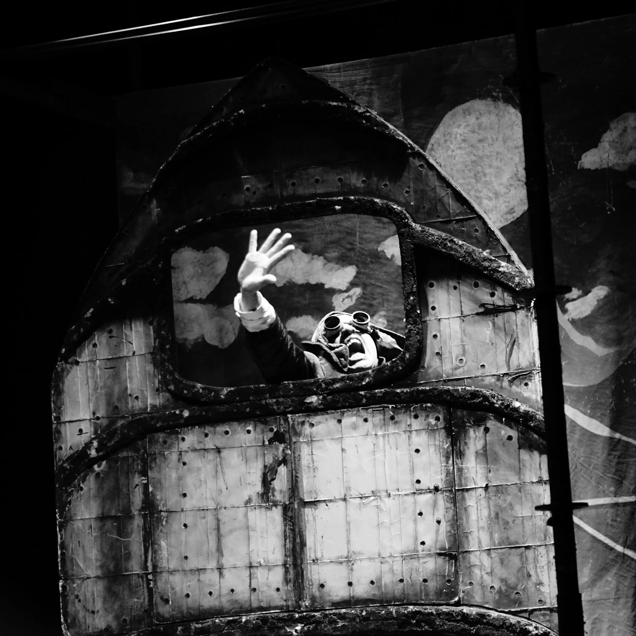 Actor saludando desde escenografía de cabina en obra teatral